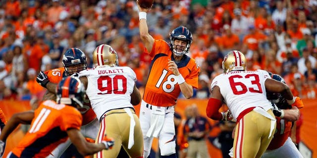 Denver Broncos quarterback Peyton Manning (18) throws as San Francisco 49ers defensive tackle Darnell Dockett (90) and Tony Jerod-Eddie (63) rush during the first half of an NFL preseason football game, Saturday, Aug. 29, 2015, in Denver. (AP Photo/Jack Dempsey)