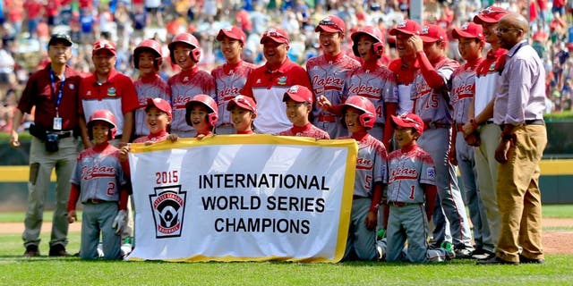 SOUTH WILLAMSPORT, PA - AUGUST 29: Members of team Japan pose with the banner after defeating team Mexico during the International Championship game of the Little League World Series at Lamade Stadium on August 29, 2015 in South Willamsport, Pennsylvania. (Photo by Rob Carr/Getty Images)