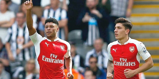 NEWCASTLE UPON TYNE, ENGLAND - AUGUST 29: Alex Oxlade-Chamberlain (L) of Arsenal celebrates his team's first goal, own goal by Fabricio Coloccini of Newcastle United during the Barclays Premier League match between Newcastle United and Arsenal at St James' Park on August 29, 2015 in Newcastle upon Tyne, England. (Photo by Dean Mouhtaropoulos/Getty Images)