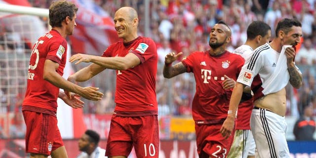 MUNICH, GERMANY - AUGUST 29: Thomas Mueller (L-R), Arjen Robben and Arturo Vidal of FC Bayern Muenchen celebrate scoring the opening goal during the Bundesliga match between FC Bayern Muenchen and Bayer Leverkusen at Allianz Arena on August 29, 2015 in Munich, Germany. (Photo by L. Preiss/Getty Images for FC Bayern)