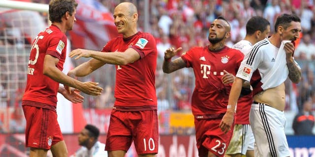 MUNICH, GERMANY - AUGUST 29: Thomas Mueller (L-R), Arjen Robben and Arturo Vidal of FC Bayern Muenchen celebrate scoring the opening goal during the Bundesliga match between FC Bayern Muenchen and Bayer Leverkusen at Allianz Arena on August 29, 2015 in Munich, Germany. (Photo by L. Preiss/Getty Images for FC Bayern)