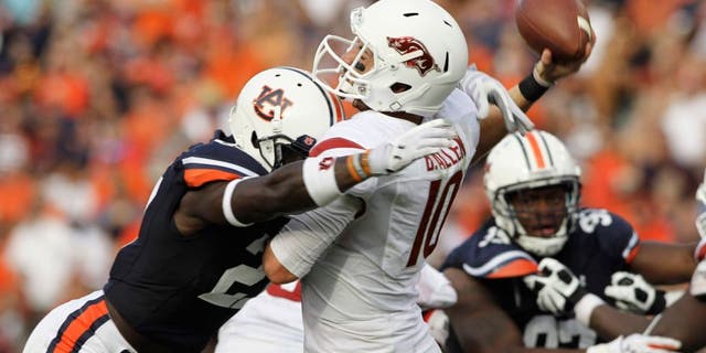 Aug 30, 2014; Auburn, AL, USA; Arkansas Razorbacks quarterback Brandon Allen (10) is hit by Auburn Tigers defensive back Robenson Therezie (27) during the second half at Jordan Hare Stadium. Mandatory Credit: John Reed-USA TODAY Sports