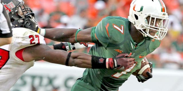 Miami's Gus Edwards pushes off Arkansas State's Money Hunter as he scores a second-quarter touchdown on a 27-yard run at Sun Life Stadium in Miami Gardens, Fla., on Saturday, Sept. 13, 2014. (Charles Trainor Jr./Miami Herald/MCT)