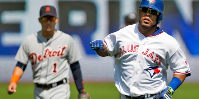 Toronto Blue Jays' Edwin Encarnacion, right, rounds the bases after hitting a solo home run off Detroit Tigers starting pitcher Alfredo Simon as Tigers' shortstop Jose Iglesias, left, looks on during first-inning baseball game action in Toronto, Sunday, Aug. 30, 2015. (Chris Young/The Canadian Press via AP) MANDATORY CREDIT