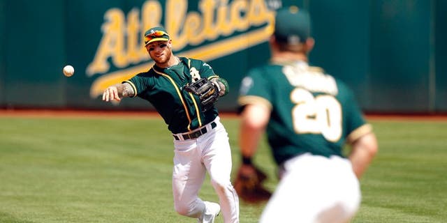 Aug 23, 2015; Oakland, CA, USA; Oakland Athletics infielder Brett Lawrie (15) throws the ball to first to record an out against the Tampa Bay Rays in the fifth inning at O.co Coliseum. The Athletics defeated the Rays 8-2. Mandatory Credit: Cary Edmondson-USA TODAY Sports
