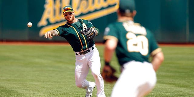Aug 23, 2015; Oakland, CA, USA; Oakland Athletics infielder Brett Lawrie (15) throws the ball to first to record an out against the Tampa Bay Rays in the fifth inning at O.co Coliseum. The Athletics defeated the Rays 8-2. Mandatory Credit: Cary Edmondson-USA TODAY Sports