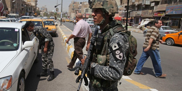 Aug. 31: An Iraqi police officer stands at a checkpoint in Baghdad, Iraq.