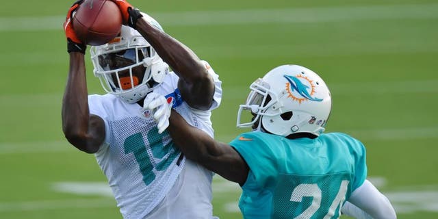 Aug 11, 2015; Davie, FL, USA; Miami Dolphins wide receiver Michael Preston (19) hauls in a catch in front of Miami Dolphins corner back Brice McCain (24) during training camp at Doctors Hospital Training Facility. Mandatory Credit: Steve Mitchell-USA TODAY Sports