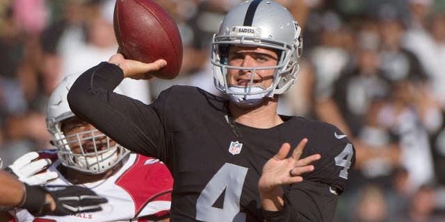 August 30, 2015; Oakland, CA, USA; Oakland Raiders quarterback Derek Carr (4) passes the football against Arizona Cardinals outside linebacker Lorenzo Alexander (97) during the first quarter in a preseason NFL football game at O.co Coliseum. Mandatory Credit: Kyle Terada-USA TODAY Sports