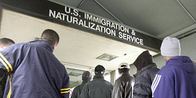 Immigrants line up outside an immigration office in Michigan. The state's governor, Rick Snyder, Republican, says foreign nationals have been an asset to the state and that Michigan's ailing economy needs to attract more immigrants.