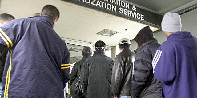 Immigrants line up outside an immigration office in Michigan. The state's governor, Rick Snyder, Republican, says foreign nationals have been an asset to the state and that Michigan's ailing economy needs to attract more immigrants.