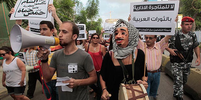 Aug. 15: Lebanese anti-Syrian regime protesters shout slogans against Syrian President Bashar Assad as they hold up Arabic placards as they protest during a demonstration in Beirut, Lebanon.