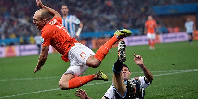 Netherlands' Arjen Robben goes down under a challenge from Argentina's Martin Demichelis during the World Cup semifinal soccer match between the Netherlands and Argentina at the Itaquerao Stadium in Sao Paulo Brazil, Wednesday, July 9, 2014. (AP Photo/Martin Meissner)