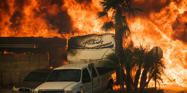 Flames consume a home on Via Arroyo as a wildfire rages in Ventura, California, Tuesday