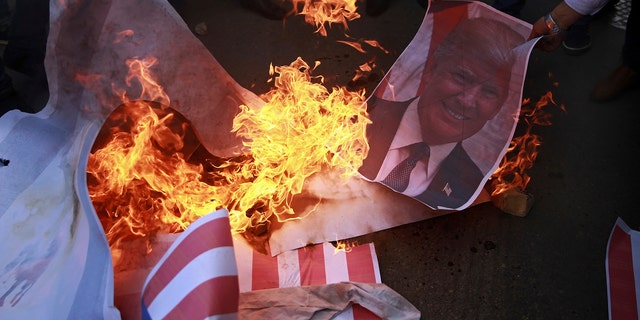 Palestinian protesters burn a poster of PresidentTrump and a representation of an American flag earlier in December.