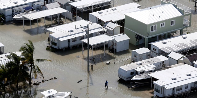 A person walks through the flooded streets of a trailer park in the aftermath of Hurricane Irma, Monday, Sept. 11, 2017, in Key Largo, Fla. (AP Photo/Wilfredo Lee)