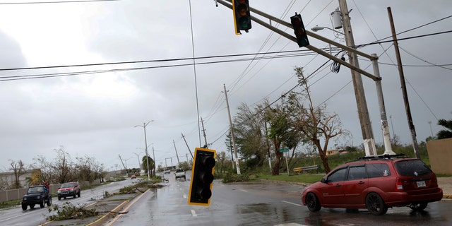Cars drive past a damaged traffic light after the area was hit by Hurricane Maria en Guayama, Puerto Rico September 20, 2017.