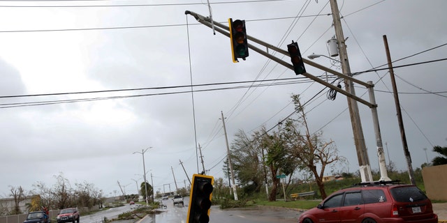Cars drive past a damaged traffic light after the area was hit by Hurricane Maria en Guayama, Puerto Rico September 20, 2017.
