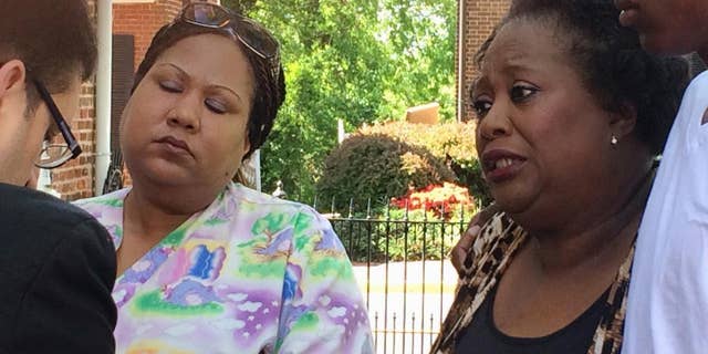 Katherine Thompson, left, daughter of Jammie Lane, and Youdella Allen, Lane's wife in 2009, talk with authorities after a news conference in Leesburg, Va., Tuesday, May 2, 2017, in which authorities announce that an alleged serial killer, Elias Abuelazam, confessed to the stabbing death of Lane eight years ago. (AP Photo/Matthew Barakat)