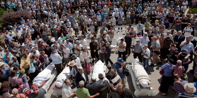Sept. 1: Israeli mourners stand around the bodies of four people who were killed in a Palestinian shooting attack when they drove through the West Bank as a new round of Mideast talks opened in Washington.