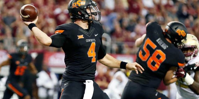 Aug 30, 2014; Arlington, TX, USA; Oklahoma State Cowboys quarterback J.W. Walsh (4) throws against the Florida State Seminoles during the first quarter at AT&T Stadium. Mandatory Credit: Matthew Emmons-USA TODAY Sports