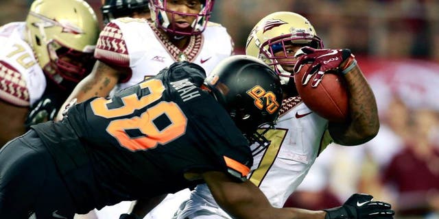 Aug 30, 2014; Arlington, TX, USA; Oklahoma State Cowboys defensive end Emmanuel Ogbah (38) tackles Florida State Seminoles running back Mario Pender (7) during the third quarter at AT&T Stadium. Mandatory Credit: Tim Heitman-USA TODAY Sports