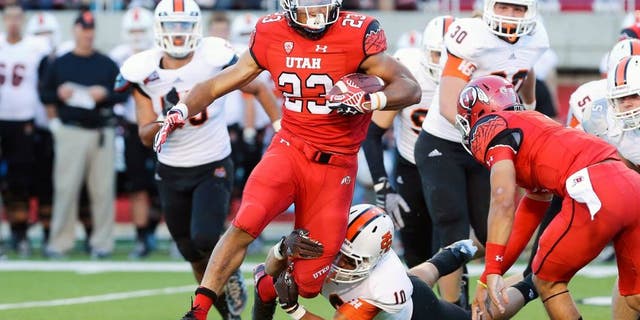 Aug 28, 2014; Salt Lake City, UT, USA; Utah Utes running back Devontae Booker (23) carries the ball as Idaho State Bengals defensive back Taison Manu (10) chases during the third quarter at Rice-Eccles Stadium. The Utes won 56-14. Mandatory Credit: Chris Nicoll-USA TODAY Sports