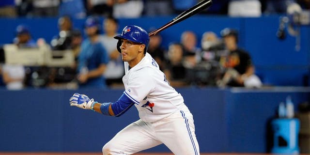 Aug 31, 2015; Toronto, Ontario, CAN; Toronto Blue Jays second baseman Ryan Goins (17) hits a single in the ninth inning against Cleveland Indians at Rogers Centre. Indians beat Jay 4 - 2. Mandatory Credit: Peter Llewellyn-USA TODAY Sports