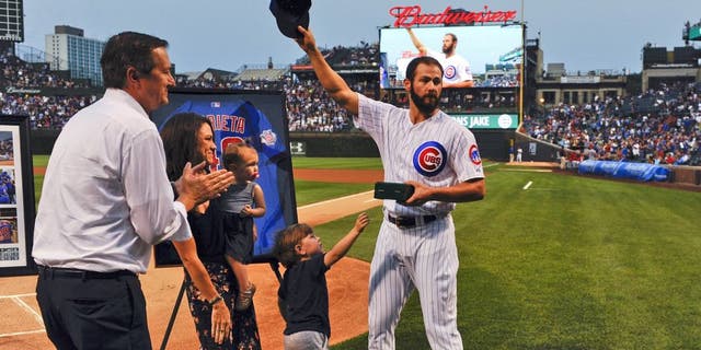 Aug 31, 2015; Chicago, IL, USA; Chicago Cubs starting pitcher Jake Arrieta (49), acknowledges the crowd while standing with his family, Cooper (son) and Palmer (daughter), Brittany Arrieta, his wife, and Chicago Cubs owner Tom Ricketts before the game against the Cincinnati Reds at Wrigley Field. Arrieta pitched a no-hitter the night before in Los Angeles. Mandatory Credit: Matt Marton-USA TODAY Sports