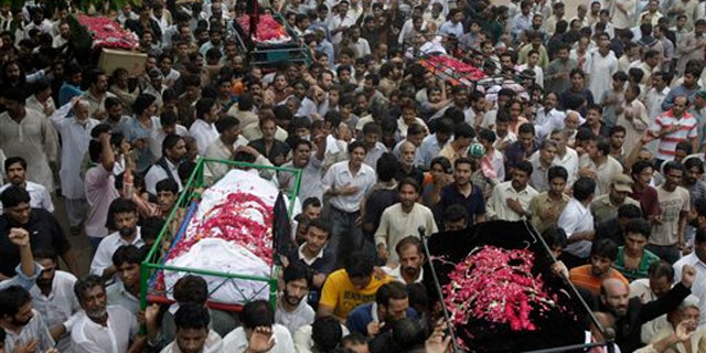 Sept. 2: Mourners carry the dead bodies of those killed in bomb blasts for burial in Lahore, Pakistan. Thousands of Shiite Muslims, thumping their chests and crying, mourned at funeral prayers for victims of the triple bombing that heaped more tragedy on Pakistan, which is already struggling to cope with devastating floods.