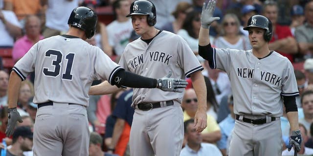 BOSTON, MA - SEPTEMBER 2: Greg Bird #31 of the New York Yankees is greeted by Chase Headley #12 and John Ryan Murphy #66 after his home run in the second inning against he Boston Red Sox at Fenway Park on September 2, 2015 in Boston, Massachusetts. (Photo by Jim Rogash/Getty Images)