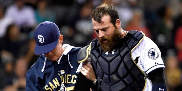SAN DIEGO, CA - SEPTEMBER 1: Derek Norris #3 of the San Diego Padres, right, comes out of the game with a trainer during the seventh inning of a baseball game against the Texas Rangers at Petco Park September, 1, 2015 in San Diego, California. (Photo by Denis Poroy/Getty Images)