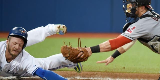 Sep 2, 2015; Toronto, Ontario, CAN; Toronto Blue Jays third baseman Josh Donaldson (20) eludes the tag of Cleveland Indians catcher Yan Gomes (10) to score in the second inning at Rogers Centre. Mandatory Credit: Dan Hamilton-USA TODAY Sports