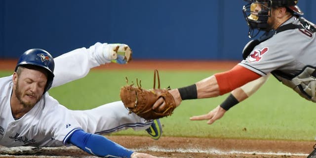 Sep 2, 2015; Toronto, Ontario, CAN; Toronto Blue Jays third baseman Josh Donaldson (20) eludes the tag of Cleveland Indians catcher Yan Gomes (10) to score in the second inning at Rogers Centre. Mandatory Credit: Dan Hamilton-USA TODAY Sports