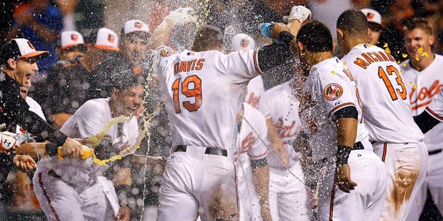 Baltimore Orioles' Chris Davis (19) is greeted as he crosses home plate after hitting a solo home run during the 11th inning of a baseball game against the Tampa Bay Rays, Wednesday, Sept. 2, 2015, in Baltimore. Baltimore won 7-6. (AP Photo/Patrick Semansky)