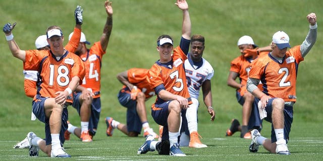 June 9, 2015; Englewood, CO, USA; Denver Broncos quarterback Peyton Manning (18) and quarterback Trevor Siemian (3) and quarterback Zac Dysert (2) warm up before the start of mini camp activities at the Broncos training facility. Mandatory Credit: Ron Chenoy-USA TODAY Sports