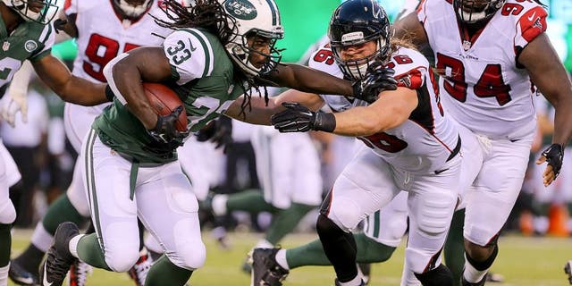 Aug 21, 2015; East Rutherford, NJ, USA; New York Jets running back Chris Ivory (33) runs with the ball while Atlanta Falcons linebacker Brooks Reed (56) attempts to tackle him during the first half at MetLife Stadium. Mandatory Credit: Ed Mulholland-USA TODAY Sports