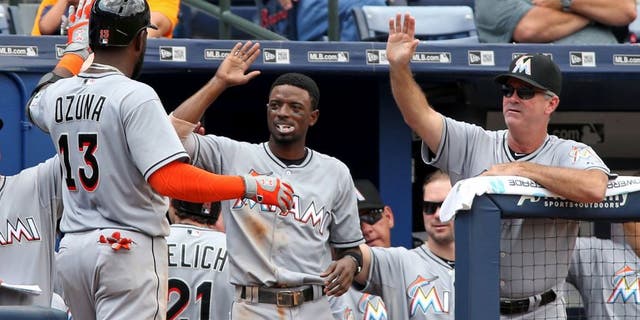 Sep 2, 2015; Atlanta, GA, USA; Miami Marlins center fielder Marcell Ozuna (13) celebrates his two-run home run with second baseman Dee Gordon (center) and manager Dan Jennings (26) in the fifth inning of their game against the Atlanta Braves at Turner Field. Mandatory Credit: Jason Getz-USA TODAY Sports