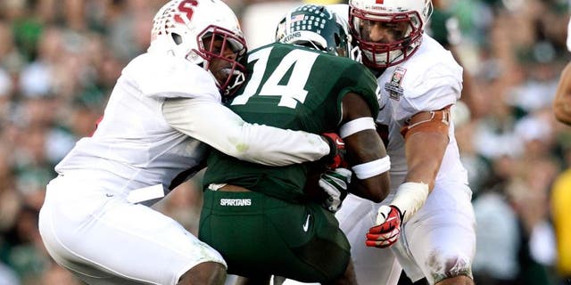 Jan 1, 2014; Pasadena, CA, USA; Stanford Cardinal safety Jordan Richards (8) and linebacker A.J. Tarpley (17) tackle Michigan State Spartans wide receiver Tony Lippett (14) during the first half at the Rose Bowl. Mandatory Credit: Robert Hanashiro-USA TODAY Sports