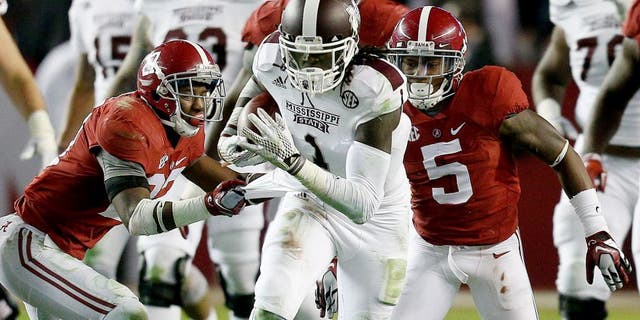 Nov 15, 2014; Tuscaloosa, AL, USA; Mississippi State Bulldogs wide receiver De'Runnya Wilson (1) is grabbed from behind by Alabama Crimson Tide defensive back Nick Perry (27) at Bryant-Denny Stadium. Mandatory Credit: Marvin Gentry-USA TODAY Sports