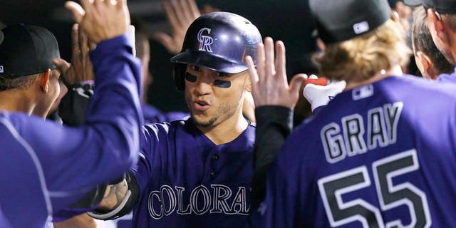 Colorado Rockies' Carlos Gonzalez, center, is congratulated by teammates as he returns to the dugout after hitting a two-run home run off San Francisco Giants relief pitcher George Kontos in the fourth inning of a baseball game, Thursday, Sept.. 3, 2015, in Denver. (AP Photo/David Zalubowski)