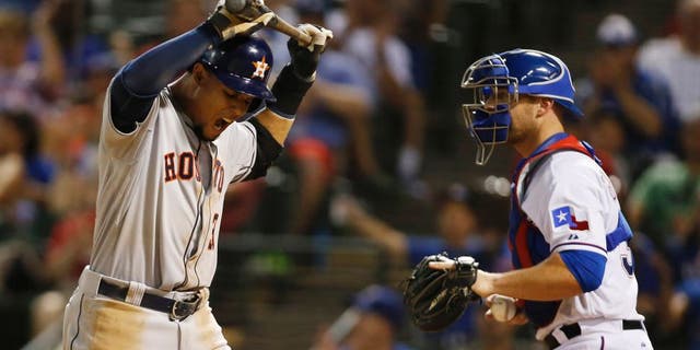 Aug 5, 2015; Arlington, TX, USA; Houston Astros center fielder Carlos Gomez (30) reacts to striking out in the ninth inning as Texas Rangers catcher Chris Gimenez (38) looks on at Globe Life Park in Arlington. Texas won 4-3. Mandatory Credit: Tim Heitman-USA TODAY Sports