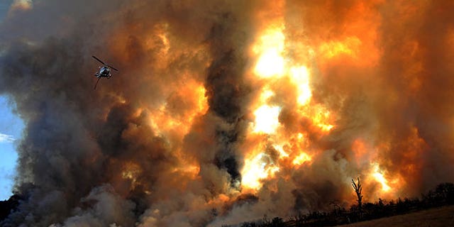 Sept. 4: A fire department helicopter flies over the smoke of a large wildfire that burned in the mountains to the southwest of Tehachapi, Calif.