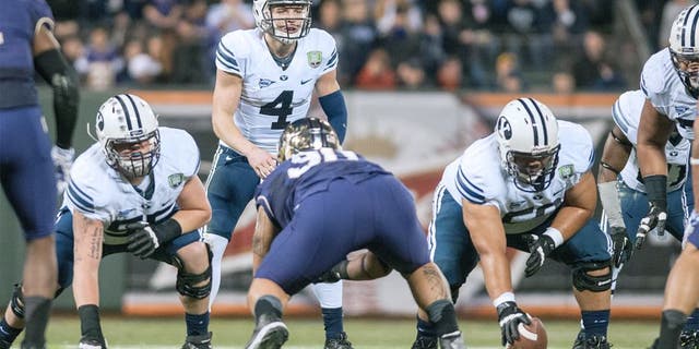 Dec 27, 2013; San Francisco, CA, USA; Brigham Young Cougars quarterback Taysom Hill (4) prepares to hike the ball against the Washington Huskies during the second quarter at AT&T Park. Mandatory Credit: Ed Szczepanski-USA TODAY Sports