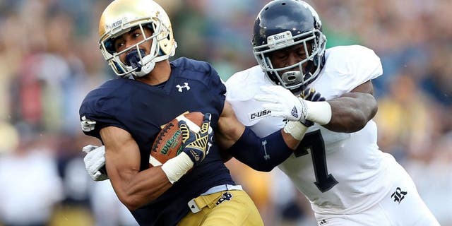 Aug 30, 2014; South Bend, IN, USA; Notre Dame Fighting Irish wide receiver Will Fuller (7) catches a pass for a 75 yard touchdown against Rice Owls safety Julius White (7) at Notre Dame Stadium. Mandatory Credit: Brian Spurlock-USA TODAY Sports