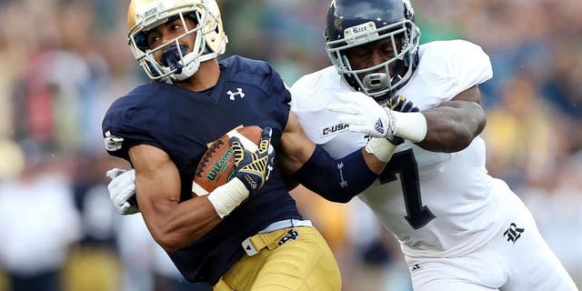 Aug 30, 2014; South Bend, IN, USA; Notre Dame Fighting Irish wide receiver Will Fuller (7) catches a pass for a 75 yard touchdown against Rice Owls safety Julius White (7) at Notre Dame Stadium. Mandatory Credit: Brian Spurlock-USA TODAY Sports