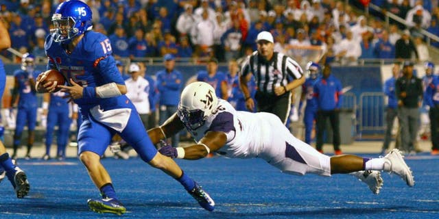 Sep 4, 2015; Boise, ID, USA; Boise State Broncos quarterback Ryan Finley (15) runs away from Washington Huskies defensive lineman Damion Turpin (66) during the first half at Albertsons Stadium. Mandatory Credit: Brian Losness-USA TODAY Sports