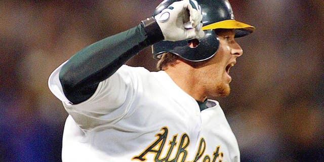 OAKLAND, UNITED STATES: Oakland Athletics' Scott Hatteberg raises his arms after hitting the game winning homerun against the Kansas City Royals 04 September 2002 during the bottom of the ninth inning off Royals' pitcher Jason Grimsley. It was the Athletics' 20th record straight win for the American League. The A's defeated the Royals 12-11. AFP PHOTO/John G. MABANGLO (Photo credit should read JOHN G. MABANGLO/AFP/Getty Images)
