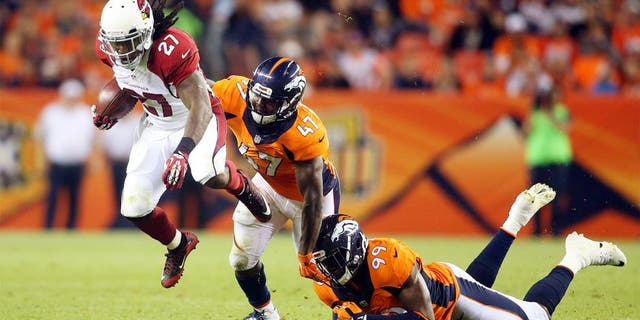 Sep 3, 2015; Denver, CO, USA; Arizona Cardinals running back Chris Johnson (27) is pursued by Denver Broncos linebackers Zaire Anderson (47) and Gerald Rivers (99) during the first half at Sports Authority Field at Mile High. Mandatory Credit: Chris Humphreys-USA TODAY Sports