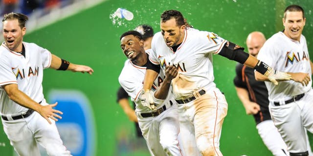 Sep 4, 2015; Miami, FL, USA; Miami Marlins third baseman Martin Prado (14) celebrates with Miami Marlins second baseman Dee Gordon (left) after Prado hit the game winning RBI single to defeat the New York Mets 6-5 in 11 inning at Marlins Park. Mandatory Credit: Steve Mitchell-USA TODAY Sports
